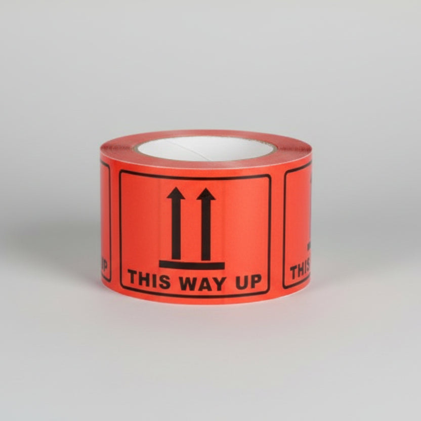 Roll of black on orange labels 'THIS WAY UP' Roll of black on orange labels 'THIS WAY UP'